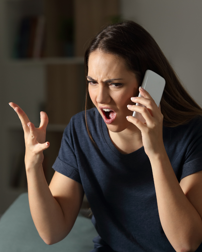 Mujer reclamando airadamente por celular